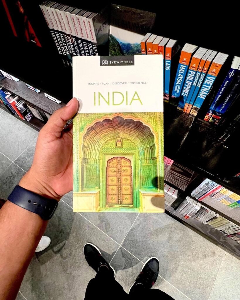 Holding an India travel guidebook in a bookshop