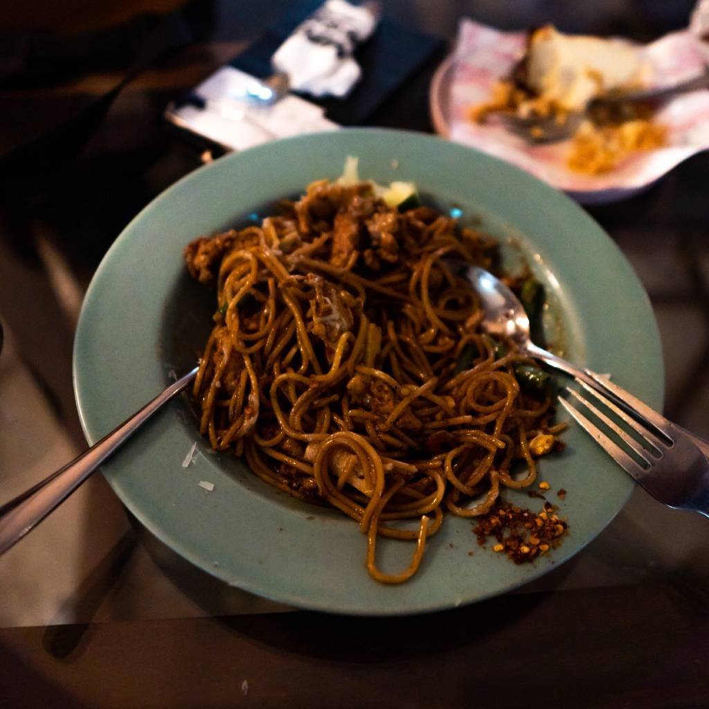 A pale green plate of dark glossy noodles with sliced meat and mushroom at The FOUNDERS Hutton