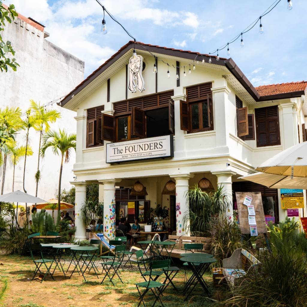 The FOUNDERS cafe in a white heritage house on Jalan Hutton, Penang, with string lights and green chairs in the yard