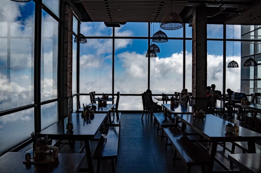 A cafe with glass walls and clouds outside the windows in Sapa